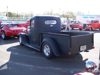 1972 Ford Ranchero - A black pickup truck is parked in a lot with other vehicles visible in the background.