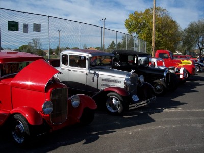 1972 Ford Ranchero - A row of vintage automobiles are parked outdoors on a sunny day.