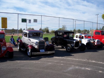 1972 Ford Ranchero - A collection of classic cars are displayed outdoors, parked in front of a chain-link fence.