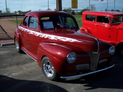 1972 Ford Ranchero - A red 1941 Ford coupe with flame decals is parked at an outdoor event.