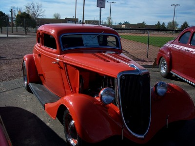 1972 Ford Ranchero - A red 1935 Ford coupe hot rod is parked at an outdoor event, with another car visible to the right.