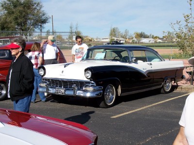 1972 Ford Ranchero - A classic two-tone black and white coupe is parked at an outdoor event, with other vehicles and people nearby.