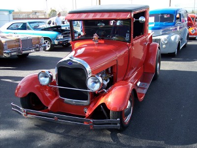 1972 Ford Ranchero - A classic red truck is displayed at an outdoor car show, with other vehicles visible in the background.