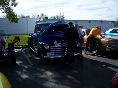 1972 Ford Ranchero - Several people examine a blue pickup truck at an outdoor car show.