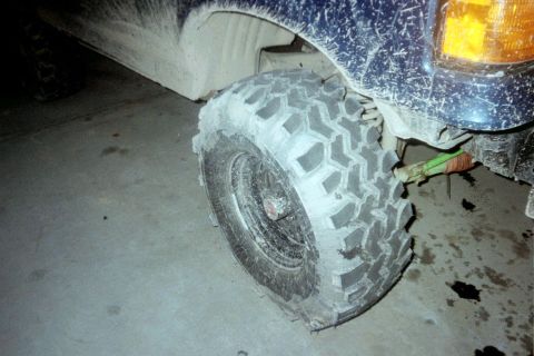 1987 Ford Bronco - Close-up of a muddy tire and fender on a 1987 Ford Bronco.