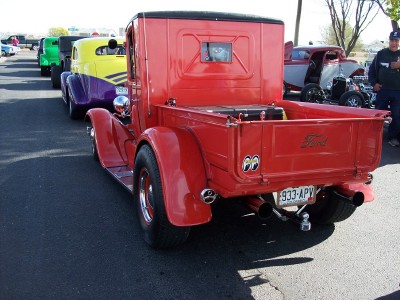 1972 Ford Ranchero - A line of vintage vehicles, including a red Ford pickup, are parked on a street.