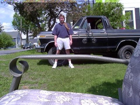 1987 Ford Bronco - A person stands beside a black Ford Bronco, with a metal pipe in the foreground.