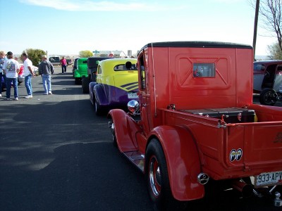 1972 Ford Ranchero - A line of classic cars, including a red pickup truck, are parked at an outdoor event.
