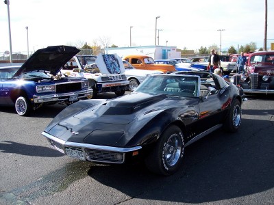 1972 Ford Ranchero - A black convertible sports car, likely a 1970s Chevrolet Corvette, is parked among other vehicles at an outdoor event.