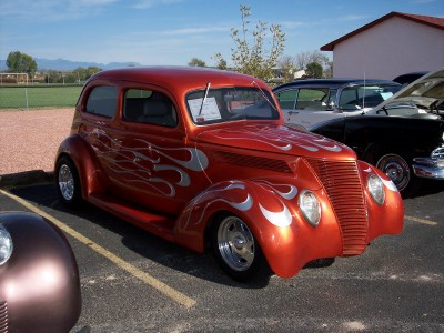 1972 Ford Ranchero - A customized sedan with flame graphics is parked at an outdoor event.