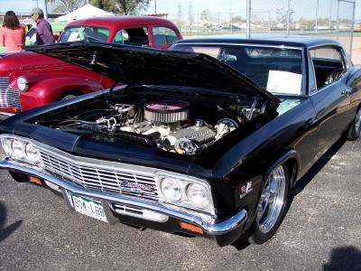1972 Ford Ranchero - Front view of a black 1965 Chevrolet Impala at a car show, engine exposed.