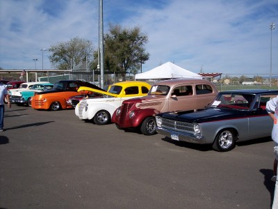 1972 Ford Ranchero - A variety of vintage automobiles are displayed outdoors under a bright, partly cloudy sky.