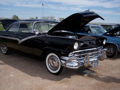 1972 Ford Ranchero - A black 1956 Ford Fairlane Crown Victoria is displayed with its hood and trunk open, alongside other vehicles.
