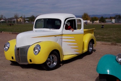 1972 Ford Ranchero - Customized 1940 Ford pickup truck with flame graphics and aftermarket wheels is parked outdoors.