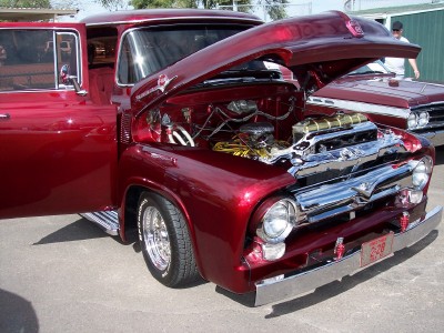 1972 Ford Ranchero - This red 1956 Ford F-series pickup truck displays its engine with the hood open, while another similar truck is visible behind it.