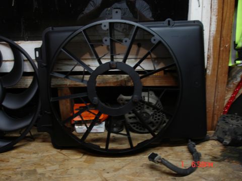 1979 Ford Bronco - Radiator fan shroud and fan blades are displayed on a workbench.