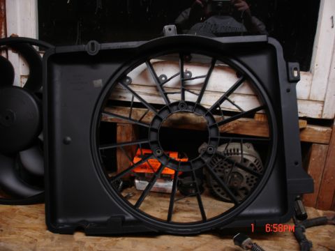 1979 Ford Bronco - A black plastic radiator fan shroud is shown, with a fan and alternator visible in the background.