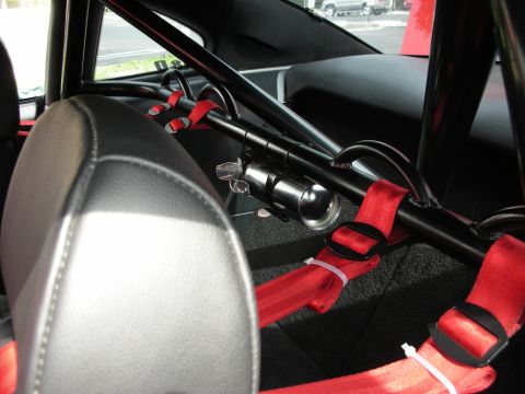 1992 Ford Crown Victoria - The interior of a car is equipped with a roll cage and red racing seatbelts.