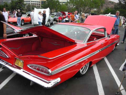 1992 Ford Crown Victoria - Custom 1959 Chevrolet Impala on display at a car show, trunk open to reveal red interior.