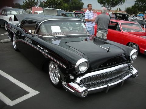 1992 Ford Crown Victoria - A classic black Buick with a distinctive grille is parked at a car show, with other vehicles visible in the background.