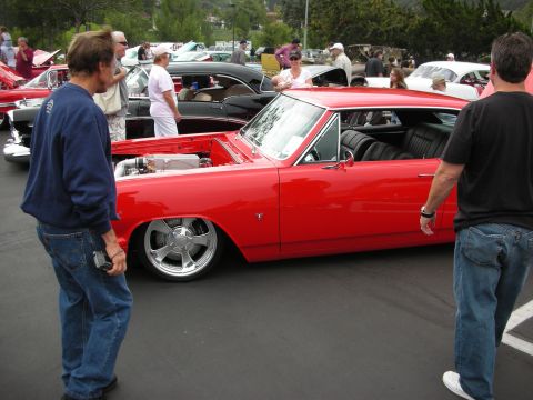 1992 Ford Crown Victoria - A red classic car is displayed with its hood open at a car show, revealing the engine compartment.