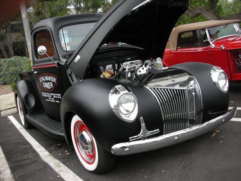 1992 Ford Crown Victoria - Custom black pickup truck with engine exposed, parked next to a red convertible.