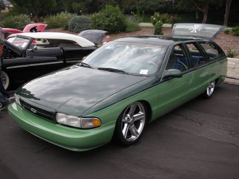 1992 Ford Crown Victoria - A two-tone green station wagon is parked at an outdoor car show.