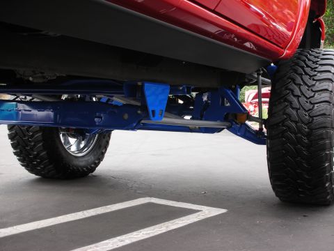 1992 Ford Crown Victoria - Custom suspension and tires are visible on a red vehicle, suggesting off-road modifications.