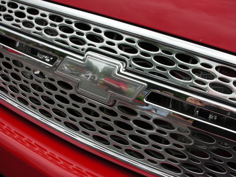 1992 Ford Crown Victoria - Close-up of a red vehicle's front grille, a prominent Chevrolet badge.