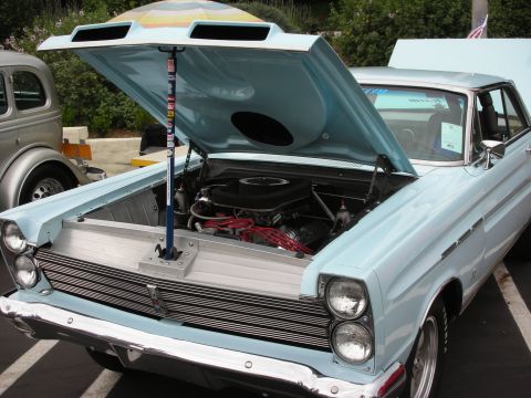 1992 Ford Crown Victoria - A light blue 1965 Mercury Comet is displayed with its hood open, revealing the engine bay.