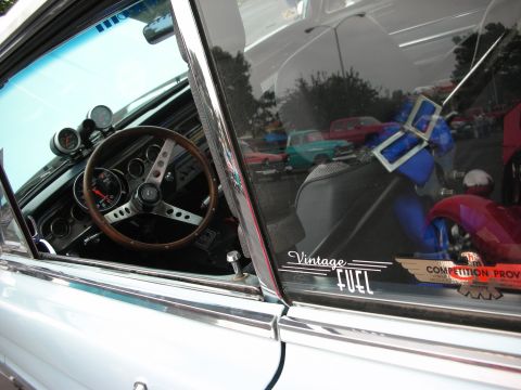 1992 Ford Crown Victoria - A view inside a classic car, aftermarket gauges and a vintage steering wheel, with other vehicles reflected in the glass.