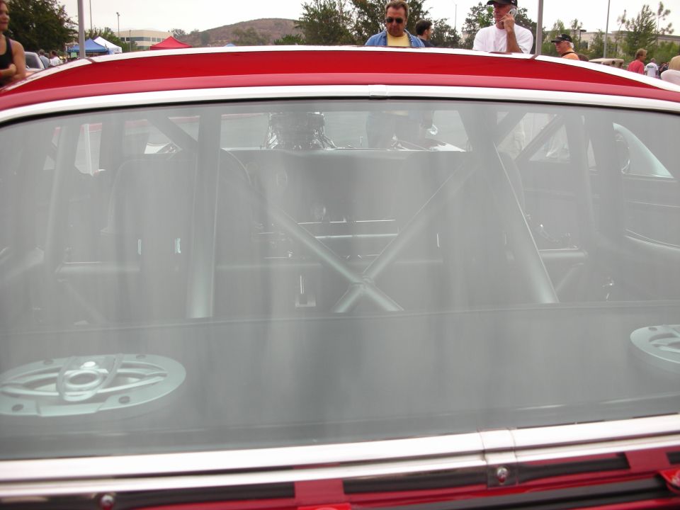 Interior roll cage visible through rear window of red car