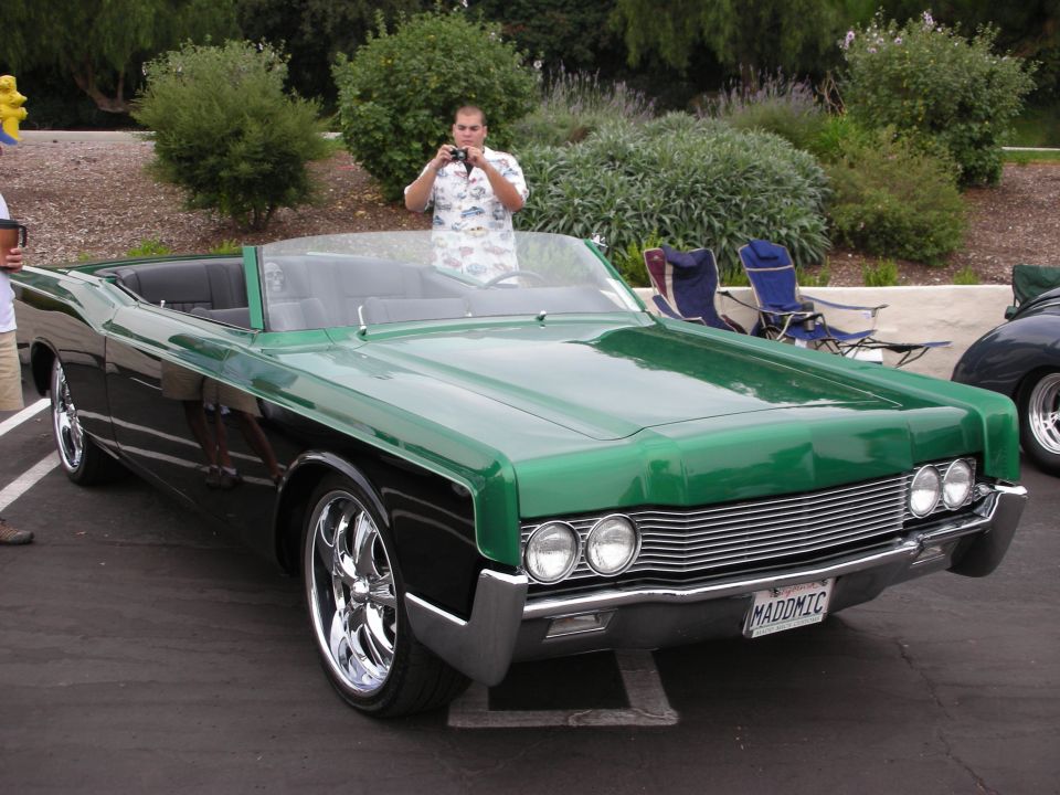 Green and black convertible with chrome wheels and a custom license plate