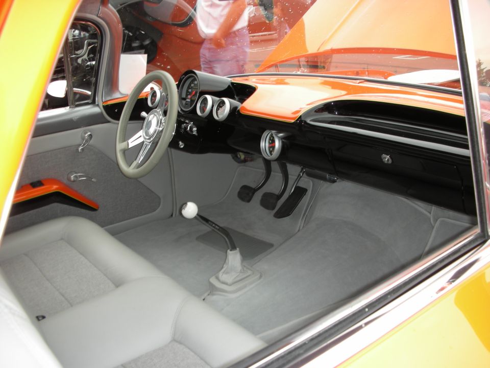 Interior view of a custom orange and gray car with bucket seats and floor shifter