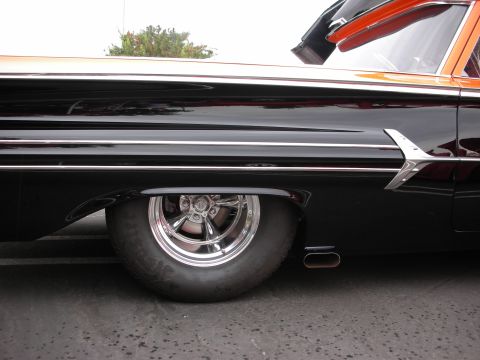 1992 Ford Crown Victoria - A custom hot rod with a two-tone black and orange paint scheme is shown from the side, focusing on the rear wheel and exhaust pipe.