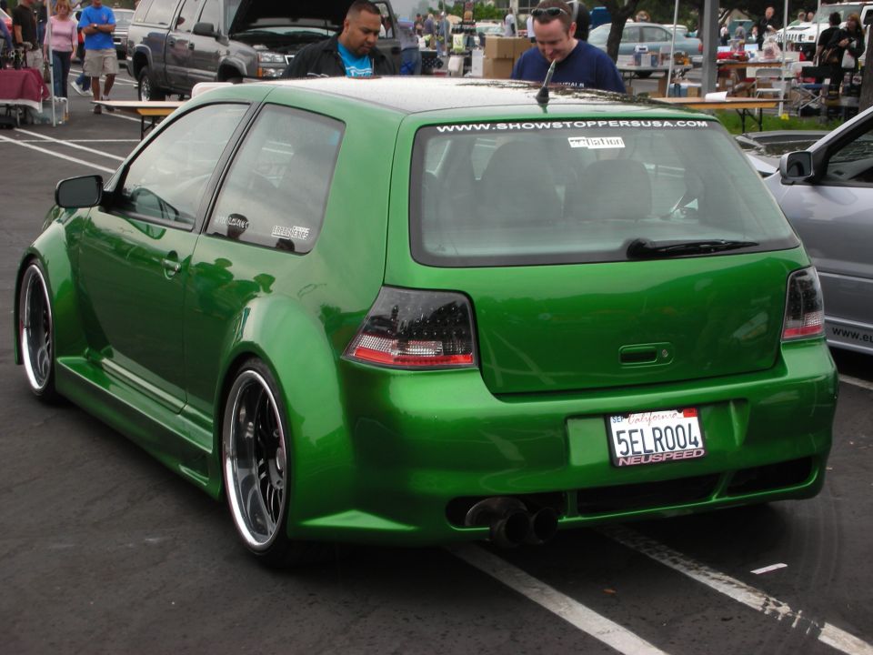 Green Volkswagen Golf GTI with widebody kit, aftermarket wheels, and tinted taillights. California license plate 5ELR004