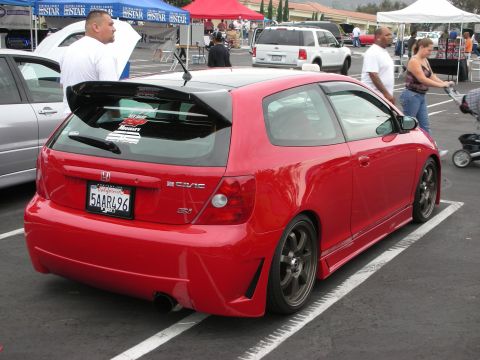 1992 Ford Crown Victoria - A red Honda Civic Si hatchback is parked at an outdoor car show, a large rear spoiler and custom wheels.