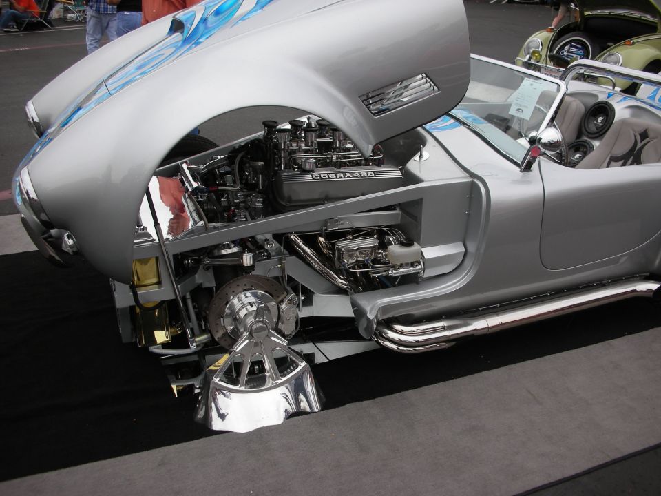 Silver convertible with exposed engine and blue flames on hood, "COBRA 427" engine cover