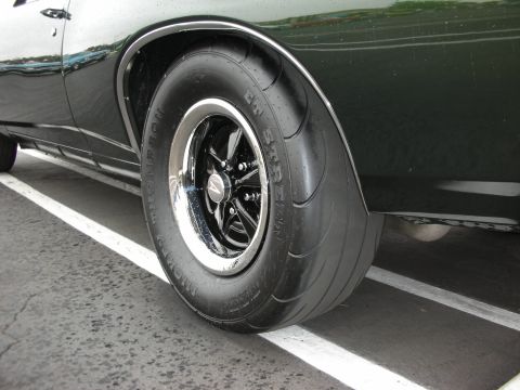 1992 Ford Crown Victoria - Close-up of a car's rear wheel and fender, showing custom rims and tires.