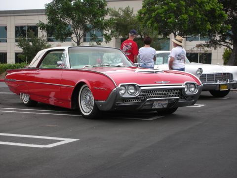 1992 Ford Crown Victoria - A red 1962 Ford Thunderbird is parked next to another classic car at a car show.