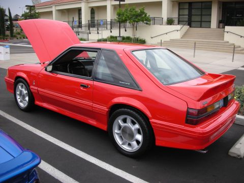 1992 Ford Crown Victoria - Red coupe with hood open, seen from the rear quarter. The vehicle appears to be a Ford Mustang, not a 1992 Ford Crown Victoria.