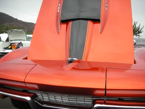 1992 Ford Crown Victoria - Front view of an orange 1969 Corvette Stingray, hood raised, showing racing stripes.