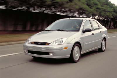 2002 Ford Focus - A silver sedan is captured in motion on a road, showing a front three-quarter perspective with motion blur.