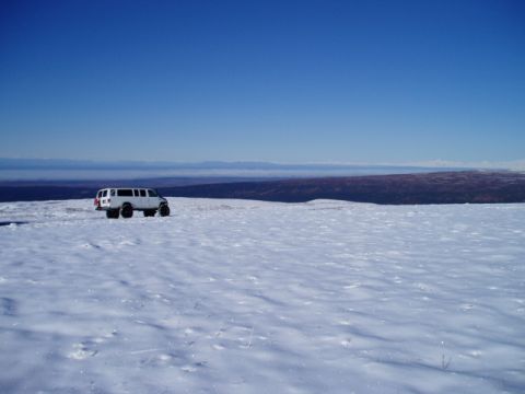 2000 Ford E350 - White Ford E350 van sits in a vast, snow-covered landscape under a clear blue sky.