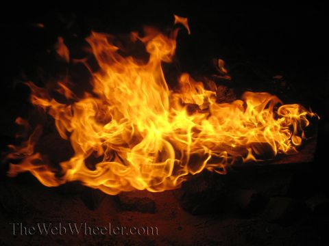 1990 Ford Bronco - wide, low spread of bright orange campfire flames at night, with a TheWebWheeler.com watermark.