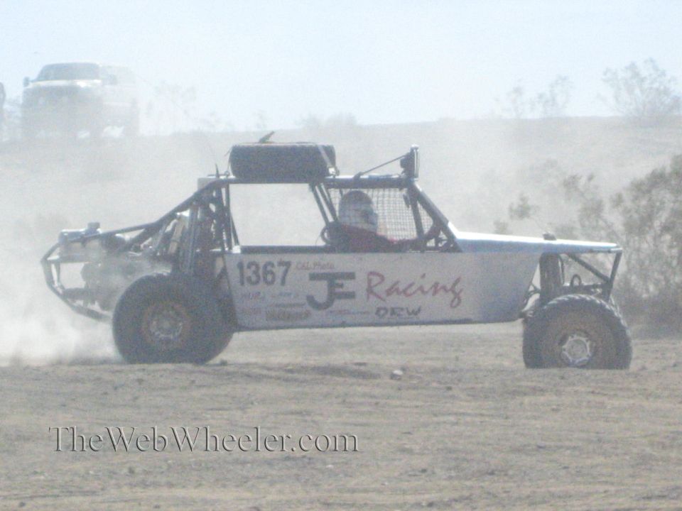Open-frame off-road buggy number 1367 JE Racing side view in desert