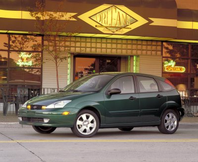 2002 Ford Focus - A green 2002 Ford Focus hatchback is shown from the front three-quarter view in front of a restaurant.