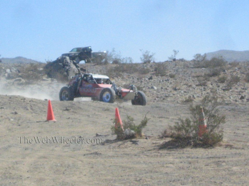 Red and white off-road buggy on a desert course near cones