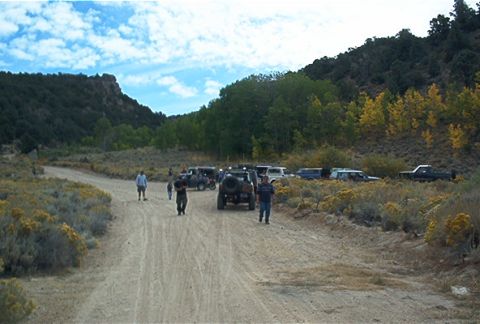 1986 Ford Bronco - Group of off-road vehicles gathered on a dirt road during an outing.