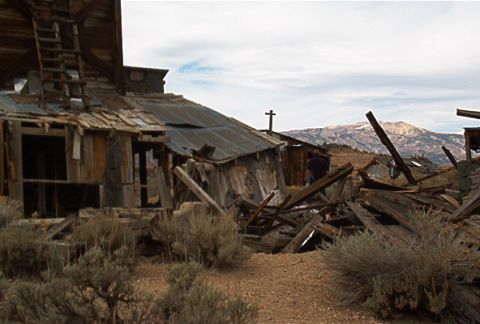 1986 Ford Bronco - Ruined buildings stand against a backdrop of mountains, suggesting a forgotten settlement.
